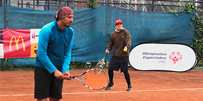 Foto que muestra a dos competidores del torneo de tenis de Olimpiadas Especiales en la Usach