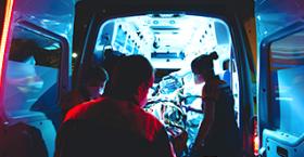 Foto que muestra a un equipo de emergencias en salud bajando a un paciente desde una ambulancia
